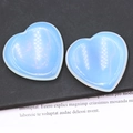 Pair of polished white opal heart-shaped worry stones with iridescent rainbow sheen - Synthetic Opal