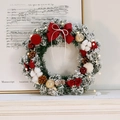 Mini snowy Christmas wreath with red bow, pine cones, and LED lights on a white table - Red Flocked Wreath With Light