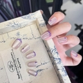 Macro detail of nude cat-eye press-on nails with purple French tips and heart accents - By1682 Qingdu Ziwei / Glue Type