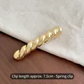 7.5cm twisted gold hair clip with spring barrette design on a textured background - Gold Twisted Spring Clip