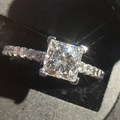 Princess cut square diamond ring in silver four-prong setting with pavé band on black box - US 7 / White Gold