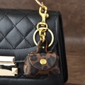 Mini-Schlüsselanhänger mit Leopardenmuster und Goldbeschlägen an schwarzer Tasche - Leopardenbraun