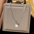 Detailed macro view of silver layered shell necklace with pearl on jewelry box - Double Layer Artificial Pearl Necklace (H1260) / Steel
