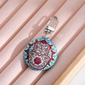 Bohemian Hamsa Hand and Om symbol round keychain with blue mandala pattern on display box - Red Floral Hamsa Hand
