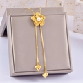 Detailed close-up of golden camellia flower necklace with white pearl and heart pendants - Camellia