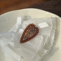 Detail of heart-shaped acetate hair clip with colorful rhinestones on white lace - Lace Rhinestone Edge Heart Duckbill Clip / Caramel color