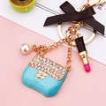 Blue mini handbag keychain with rhinestones, pearl accents, and a black ribbon bow - Sky Blue Enamel Handbag