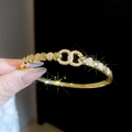 Close-up of 18k gold plated heart bangle featuring zircon paved interlocking circles - Gold (Heart Double Ring Linked)