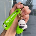 Close-up of a cute panda silicone keychain with green wrist strap and gold metal ring - Bamboo Panda - Holding Bamboo Shoot