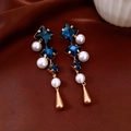 Dettaglio degli orecchini vintage con cristallo blu, perla e pendente dorato - Stile Cristallo Blu Scuro / Oro-Blu Scuro