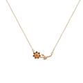 Gold floral pendant necklace with a detailed branch and central red ruby gemstone - July