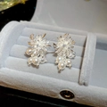 Vista macro de aretes de flores de plata con perlas y circonitas en un joyero gris claro - 78# Silver Earring Post - Plata