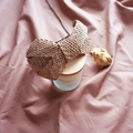 Detailed texture of brown raffia woven headband with large bow on pink fabric - Khaki Bowknot