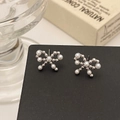 Detailed close-up of bow-knot pearl earrings on black display card with elegant finish - Silver Bow Pearl Stud Earrings