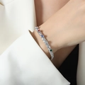 Bracciale in acciaio argento con zirconi colorati indossato su manica di giacca bianca - 15+5cm / Argento