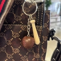 Detailed close-up of mini wooden baseball bat and leather ball keychain on a brown handbag - 4.5CM Short Bat/Coffee Ball