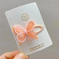 Macro detail of handmade embroidered butterfly hair clip with pink sequins on white card - Orange BB Clip