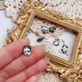 Macro detail of gothic skull ear stud with sparkling crystal facets in vintage frame - Gun Black