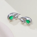 Macro shot of silver-tone teardrop earrings with vibrant green emerald stones - Silver + Green Zirconia