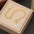 Goldenes Gliederkette-Armband mit blauem Evil-Eye-Anhänger auf einer Schmuckbox - Armband