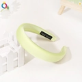 Detail of light green padded headband with a hand made label on a white background - Yellow & Green