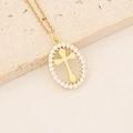 Detail view of gold-plated cross necklace with zircon stones on beige stone display - Oval Zircon Frame Cross Style (7#)