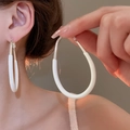 Détail de grandes créoles ovales blanches avec crochets en argent sur mannequin - Blanc-Boucles d'Oreilles Ovales