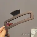 Matte dark brown 13cm rectangular claw clip for thick hair held by a model - 13cm / Dark Coffee