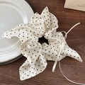 Dettaglio scrunchie crema a pois con fiocco e nastro su tavolo in legno - Scrunchie a Pois con Sciarpa (Con Fiocco a Nastro)