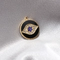 Makroaufnahme vom Evil-Eye-Anhänger mit blauen Strasssteinen auf Seidenstoff - 1 Stück / Schwarz