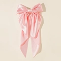 Detail of pink satin oversized bow hair clip with elegant long streamers and silky texture - Pink
