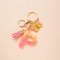 Detail of pink resin letter P keychain with glitter, tassel and butterfly pendant - Letter P