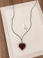 Close-up of a handmade red beaded heart pendant on a black cord necklace in a tray - Red Beaded Heart (XL0485)