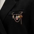 Detail view of golden cross and saint medal charms on vintage chain safety pin brooch - Retro Jesus Icon Style (K-927)