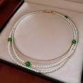 Detalle de collar de perlas de doble capa con cuentas verdes y herrajes dorados - Collar-Blanco