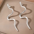 Boucles d'oreilles serpent argentées au fini métallique poli sur une boîte en cuir élégante - Argenté