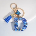 Blue resin letter D keychain with gold foil flakes, matching tassel and butterfly charm - Letter D