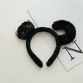Dettaglio di un cerchietto per gatti in morbido peluche nero con orecchie e coda su rivista - Fascia in Peluche Gatto Nero