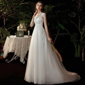 Elegant white lace wedding dress with sheer sleeves and sequin embroidery in a forest setting - US size 2(S) / Ivory
