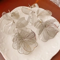 Macro view of silver floral earrings featuring delicate metal mesh hollow petals - Silver (Silver Pin)