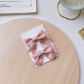 Set of two pink satin bow hair clips for girls displayed on a light wood background - Light Pink Bow 2-Piece Set