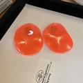Detail of two orange resin flower charms with irregular shape on a display tray - 26# Silver Needle-Orange Red Resin Disc