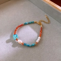 Primo piano di una collana di perle d'acqua dolce e pietre blu in una scatola portagioie - Bracciale-Blu
