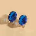 Dettaglio di orecchini ovali con pietre blu e incastonatura in metallo argento - Blu Reale (Base Argento)