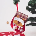Detail of red plush Christmas stocking with reindeer pattern hanging on a festive tree branch - Small Plaid Cuff Reindeer Stocking