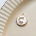 Macro view of gold-plated letter C pendant with sparkling zircons and white shell - C Round