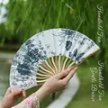 Classic Chinese folding fan with blue floral patterns and grey tassel on bamboo ribs - Ink Lilac Keel Style