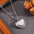 Dettaglio ravvicinato del ciondolo a cuore in metallo argento con zirconi bianchi e trafori - Stile Cuore a Graticcio Traforato Argento (T026)