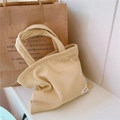 Detail shot of beige corduroy mini tote bag showing soft texture and simple white label - Light Yellow
