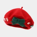 Close-up of red wool beret with green bow, Santa Claus and Christmas tree decorations - Red (Christmas Style 4)